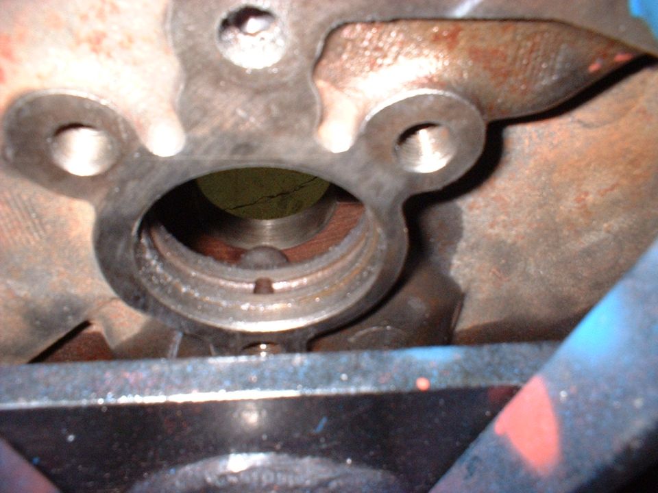 Close-up of engine block internal opening with rust and threading.