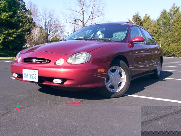 Red sedan parked in lot. License plate is ALK-9539