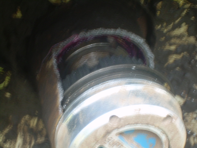 Close-up of a dirty metal hub assembly with purple grease visible.