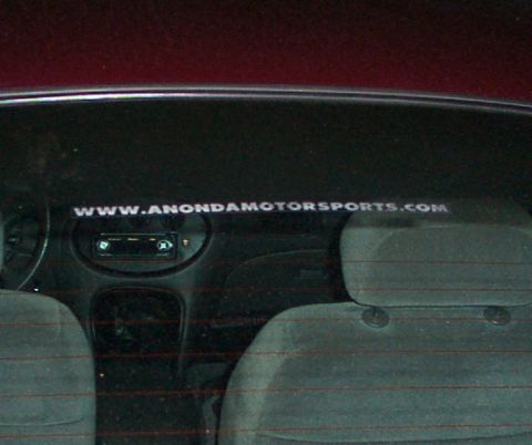 1998 Ford Taurus - Car interior with 'WWW.ANONDAMOTORSPORTS.COM' and 'SUPERMOTORS' stickers on the rear window.