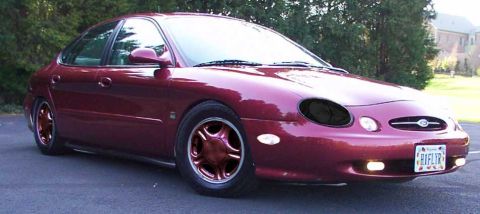 1998 Ford Taurus - This 1998 Ford Taurus is shown in a front 3/4 view, highlighting its distinctive body style and red paint.