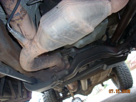 2004 Ford Ranger - The exhaust system of a 2004 Ford Ranger, including the catalytic converter and an oxygen sensor, is visible from underneath.