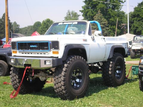 1995 Ford Bronco - Modified 1973 GMC K5 Blazer with large off-road tires and custom blue accents.