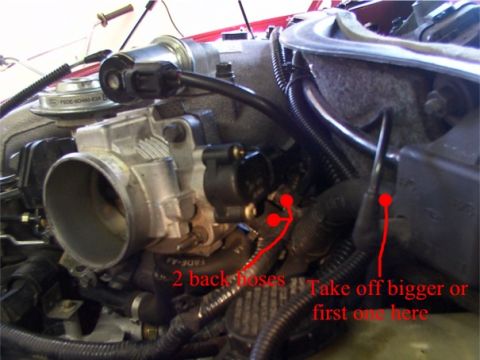 1998 Ford Taurus - Close-up view of engine components, including the throttle body and manifold, with instructional arrows and text.