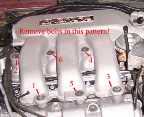 1998 Ford Taurus - Close-up of an engine intake manifold showing numbered bolts and removal instructions.