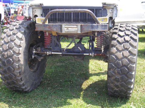 1995 Ford Bronco - This heavily modified off-road vehicle features oversized tires and a custom front bumper, obscuring its original make and model.