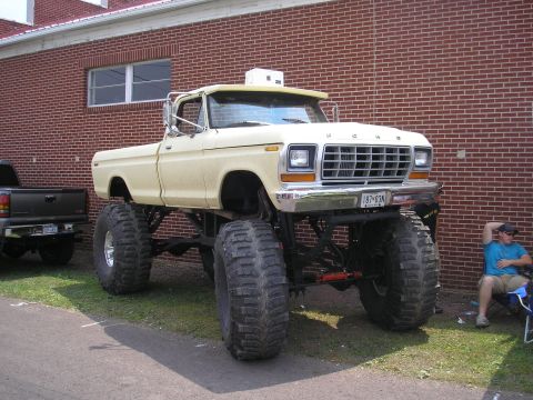 1995 Ford Bronco - This lifted pickup truck features oversized tires and a distinctive grille, suggesting a model from the late 1970s.