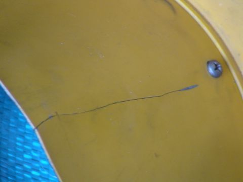 1993 Ford C-350 (Centurion Conversions) - Close-up of a damaged yellow surface with a visible crack and a screw.