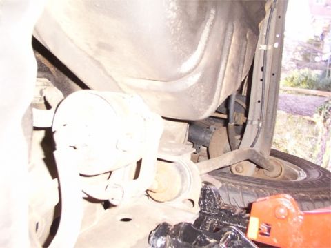 1998 Ford Taurus - Close-up view of the undercarriage of a vehicle, showing suspension parts and a tire.