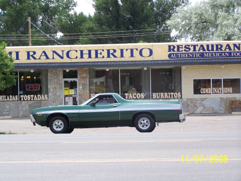 1973 Ford Mustang - A green 1970s era pickup truck with a silver stripe is parked in front of a Mexican restaurant. The restaurant sign reads "MI RANCHERITO RE…