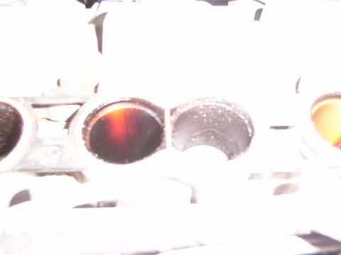 1998 Ford Taurus - The image shows the intake ports of an engine, with one port appearing dirty and the other showing signs of moisture.