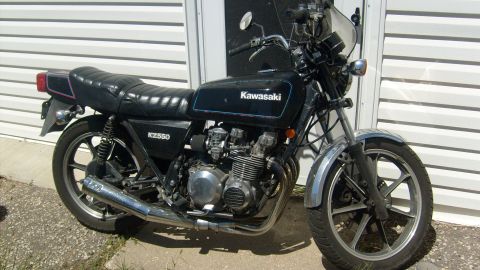 1995 Ford Bronco - A black Kawasaki KZ550 motorcycle is parked in front of a white vinyl sided building. The motorcycle has a chrome exhaust and silver alloy…