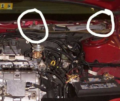 1998 Ford Taurus - Close-up of a vehicle's engine bay, focusing on the battery and various electrical connections.