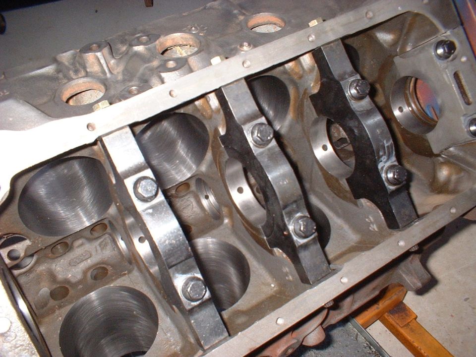 Bare V8 engine block with machined cylinder bores and bolted main caps