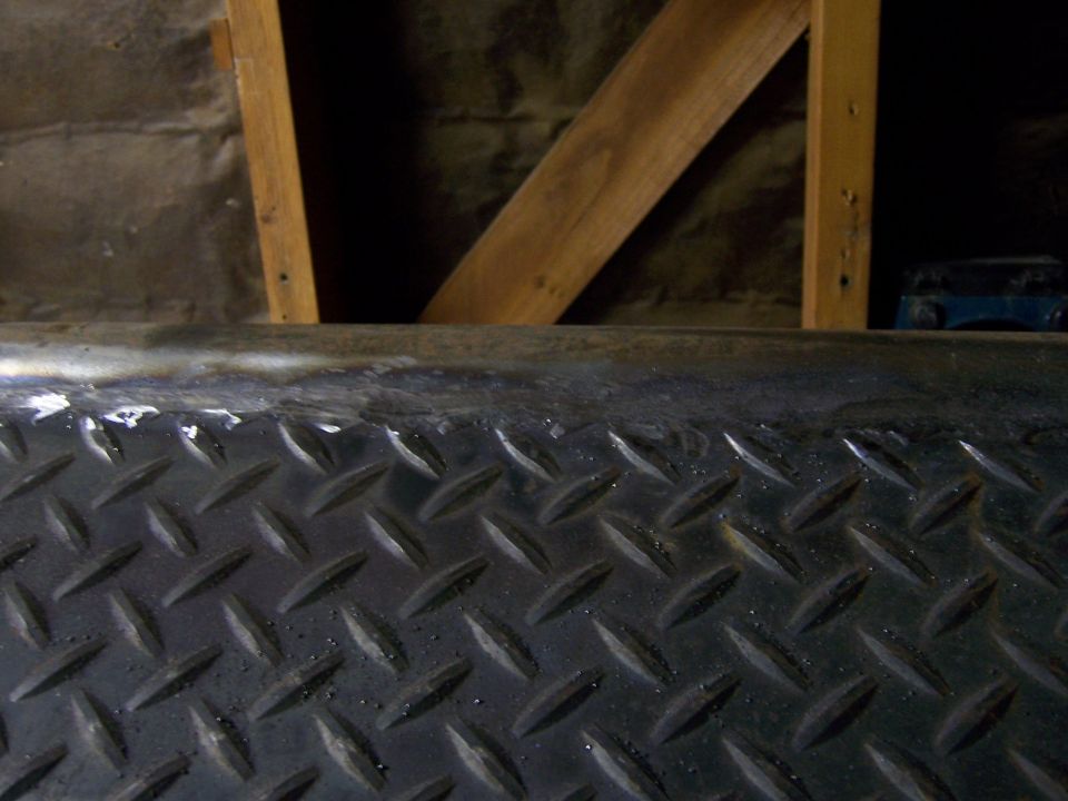Diamond plate metal surface with wooden beams above