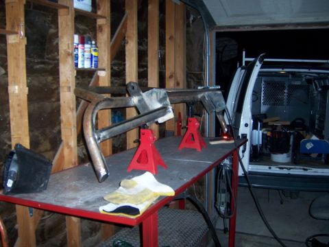 1991 Ford Bronco - A custom front bumper is being fabricated and welded on a workbench, with a van visible in the background.