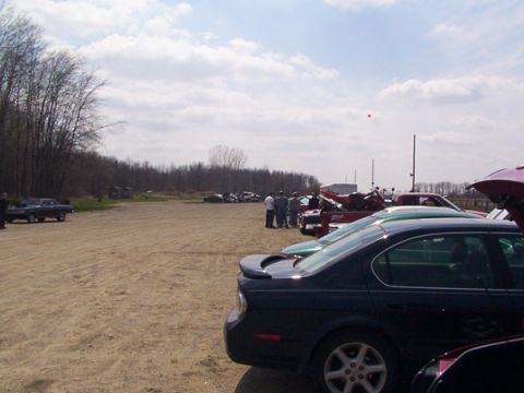 1998 Ford Taurus - Several cars are parked in an outdoor lot under a cloudy sky.