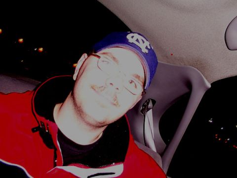 1998 Ford Taurus - A man with glasses and a blue cap is seen from the chest up inside a vehicle.