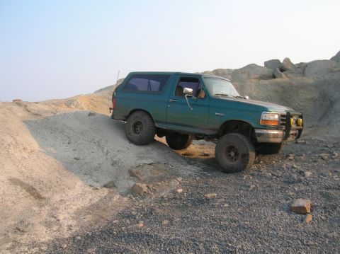 1996 Ford Bronco - This 1996 Ford Bronco is captured navigating a challenging off-road course with steep inclines and loose gravel.