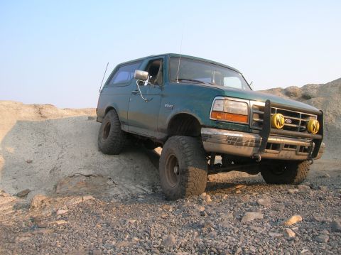 1996 Ford Bronco - 1996 Ford Bronco navigating rough terrain on a sunny day.
