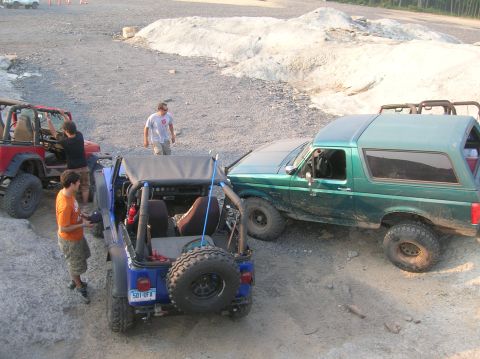 1996 Ford Bronco - A green 1996 Ford Bronco is seen off-road alongside other Jeeps.