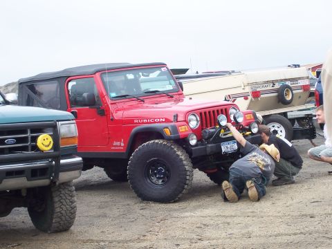 1996 Ford Bronco - A red Jeep Wrangler Rubicon is being worked on, with a green Ford Explorer parked nearby.