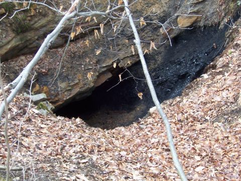 1996 Ford Bronco - Entrance to a mine or cave, with visible coal deposits and surrounding rocky terrain.