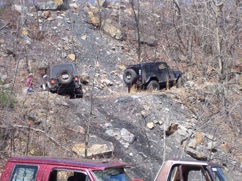 1996 Ford Bronco - Off-road vehicles tackle a challenging rocky terrain on a sunny day.