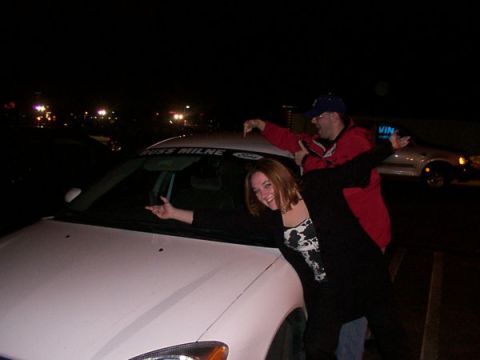 1998 Ford Taurus - Two people pose next to a white car at night, with text visible on the windshield.