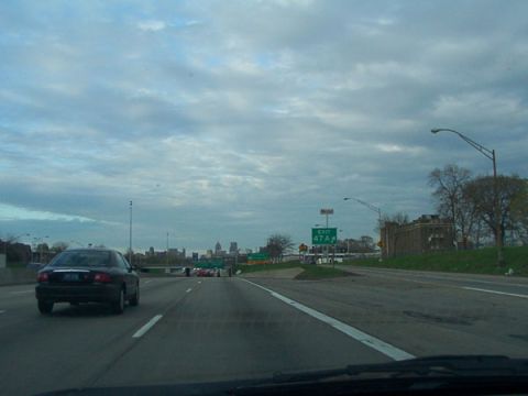 1998 Ford Taurus - A 1998 Ford Taurus is seen from behind on a highway with a city skyline in the distance.