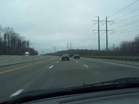 1998 Ford Taurus - A view from inside a vehicle driving on a highway, with other cars and power lines visible.