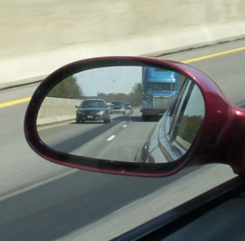 1998 Ford Taurus - View of highway traffic from a car's side mirror, showing other vehicles.
