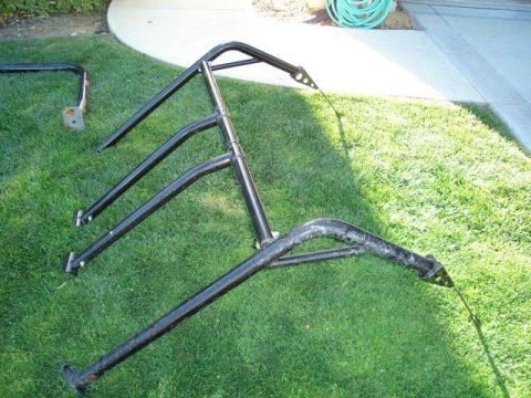 1971 Ford Bronco - Black roll cage tubing and mounting brackets are laid out on a grassy lawn.