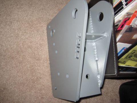 1995 Ford Bronco - A gray metal bracket with 'CHIEF' cut into its side sits on a carpeted surface next to a stack of magazines.
