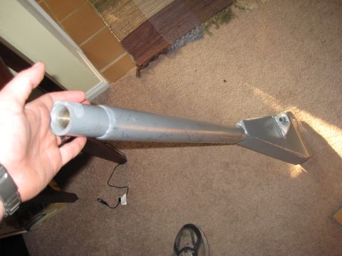 1995 Ford Bronco - A metal pipe part is held up for inspection, resting on carpeted floor.