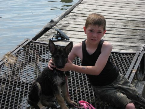 1990 Ford F-250 - A boy and his wet German Shepherd puppy sit on a wooden dock by the water.