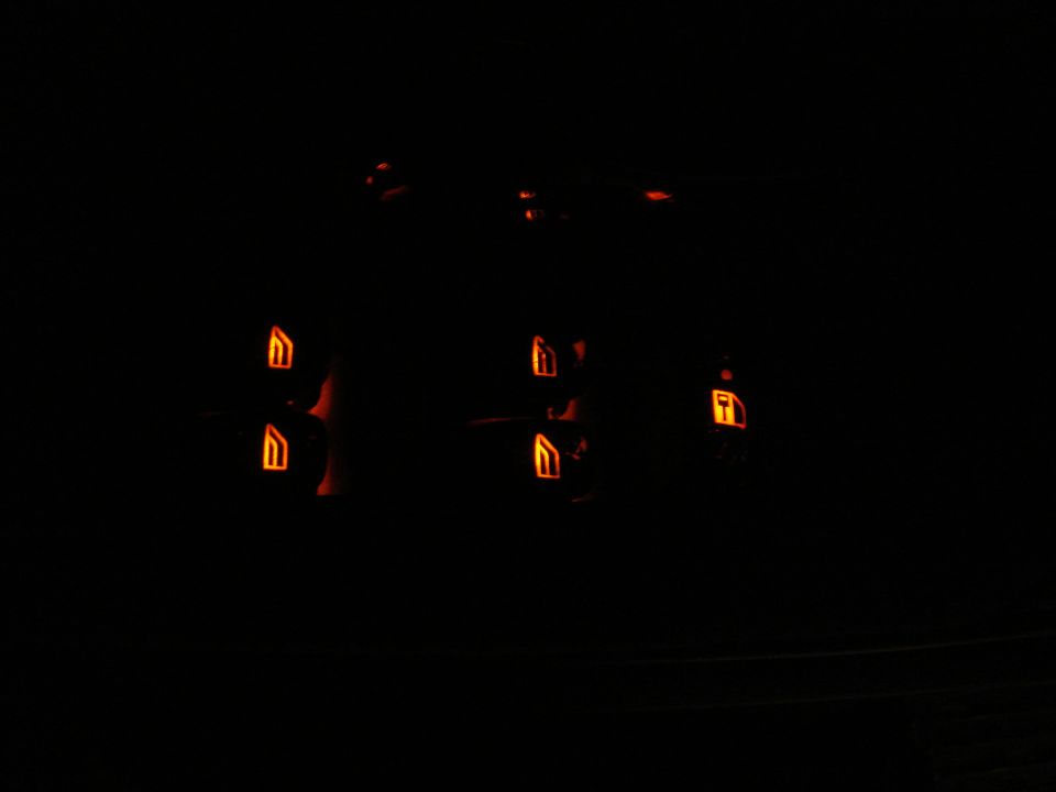 Orange-lit window and lock switch symbols glowing on a dark car door panel at night