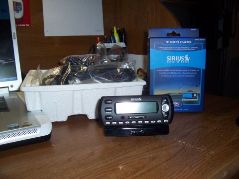 2003 Ford Ranger - SiriusXM satellite radio receiver and FM direct adapter box on a wooden desk with a laptop.