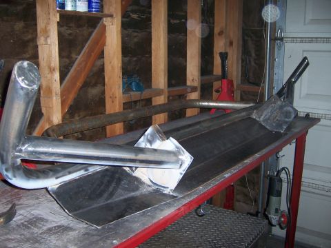 1991 Ford Bronco - Custom metal bumper parts are being fabricated and welded together on a workbench in a garage.