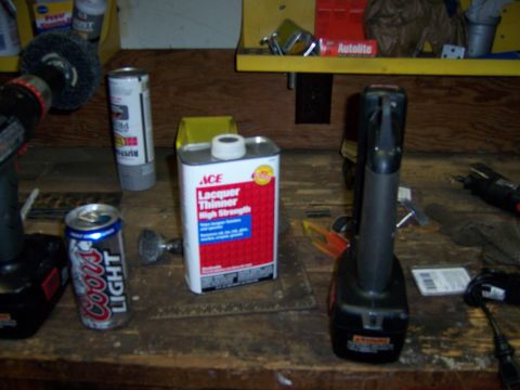 1991 Ford Bronco - A workbench is set up with tools and supplies, including two drills and a can of lacquer thinner.