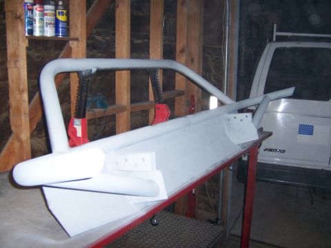 1991 Ford Bronco - A custom front bumper assembly is shown in a workshop setting, with a white vehicle visible in the background.