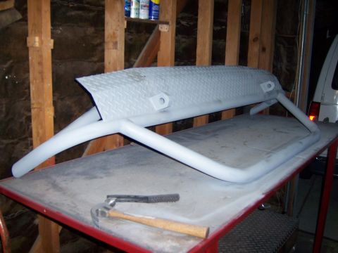 1991 Ford Bronco - A custom fabricated front bumper, likely for an off-road vehicle, sits on a workbench.