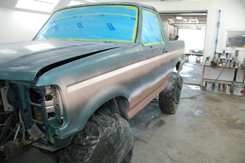 1996 Ford Bronco - A Ford Bronco is being prepped for a paint job in a workshop, with its hood open and windows covered.