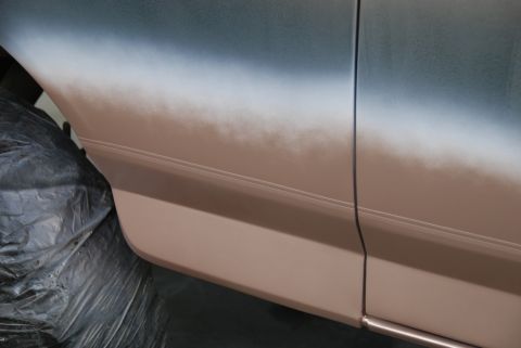 1996 Ford Bronco - The side panel of a vehicle is shown during a two-tone paint application, with a gradient from blue to brown.