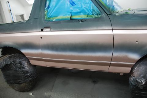 1996 Ford Bronco - Side view of a 1996 Ford Bronco undergoing a paint job, showing the two-tone color application.
