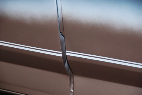 1996 Ford Bronco - Detail of a car door seam, showing pinstripes and the gap between panels.