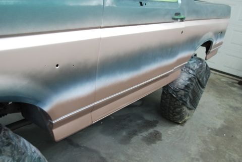 1996 Ford Bronco - Side view of a Bronco undergoing paint work, with visible body damage and trim.