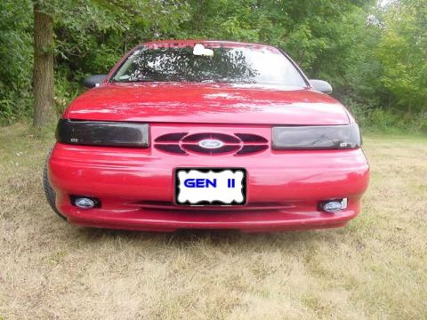 1993 Ford Taurus - The front view of a red 1993 Ford Taurus, a distinctive grille and custom license plate.