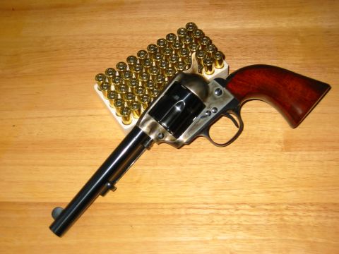1996 Ford Bronco - A revolver and a box of ammunition are placed on a wooden table.
