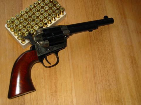 1996 Ford Bronco - A revolver and a box of ammunition are displayed on a wooden surface.